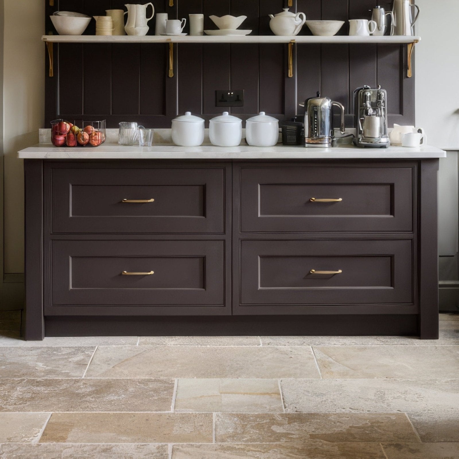 Dark brown kitchen cabinet with gold toned handles and a white marble countertop featuring vieux bourgogne limestone ancient finish