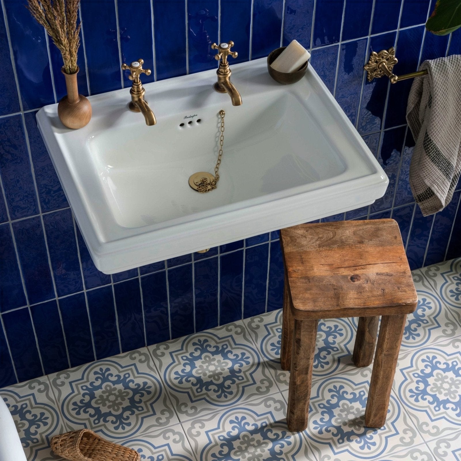 Vogue light blue stone white ceramic wall-mounted sink with brass fixtures and decorative gold chain drain cover