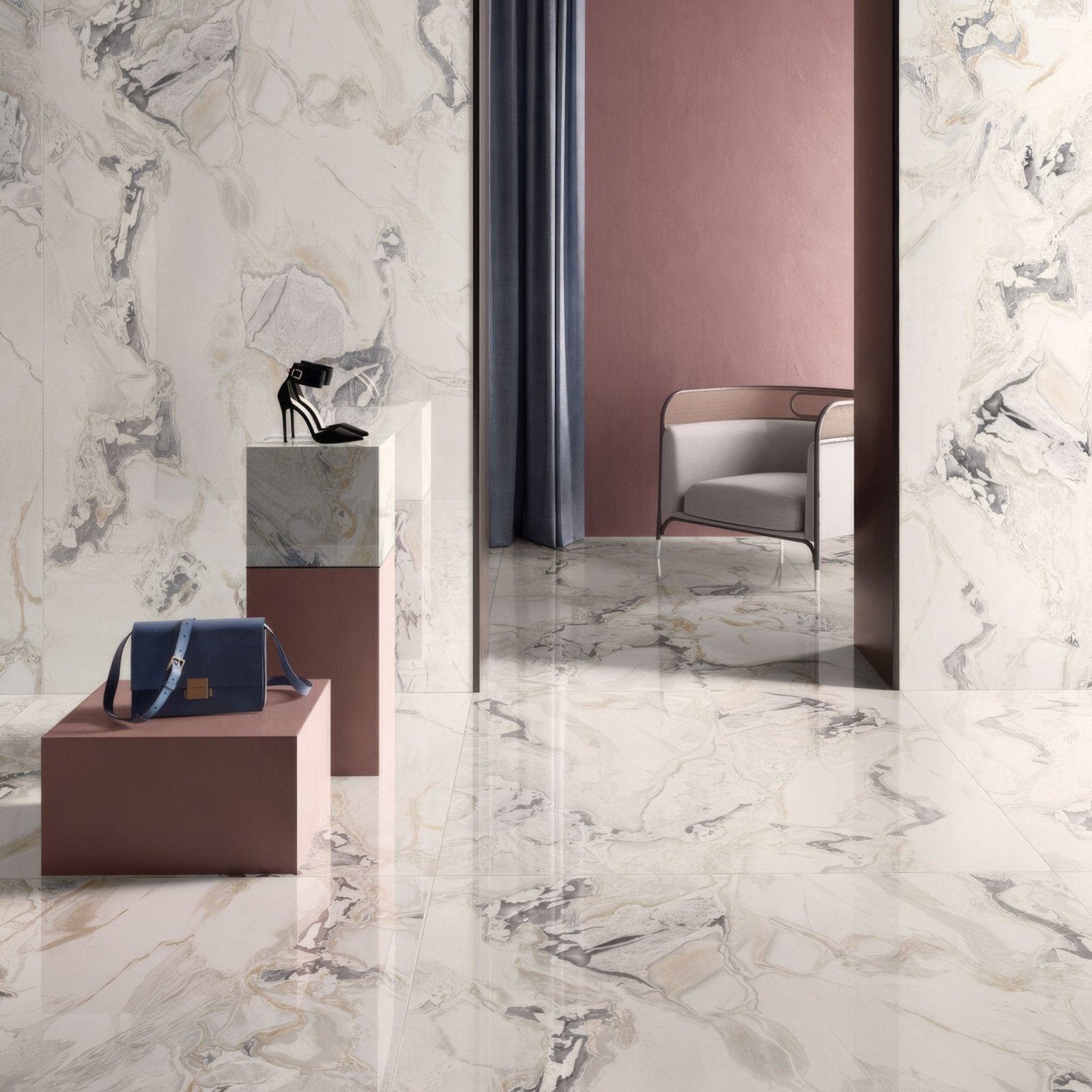 Volterra Babila Gloss 60 x 120cm cream marble-effect tiles with a navy handbag on a pedestal