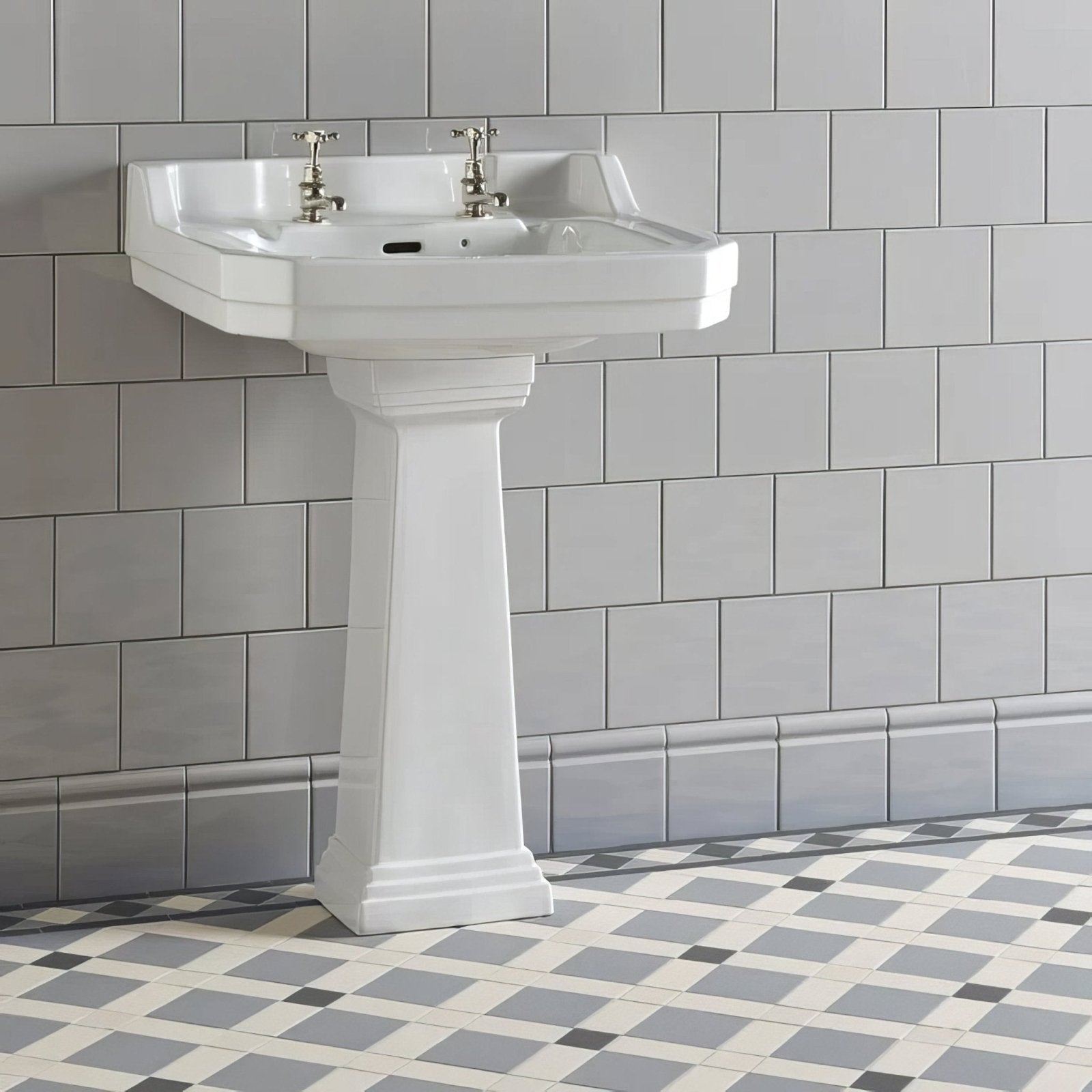 White ceramic pedestal sink with classic design and polished chrome faucets featured with westminster grey field tile