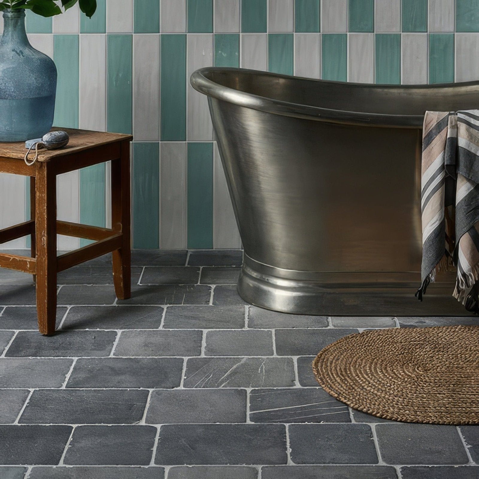 Stylish freestanding bathtub with a matte brushed metallic finish in wexford limestone cobble tumbled finish