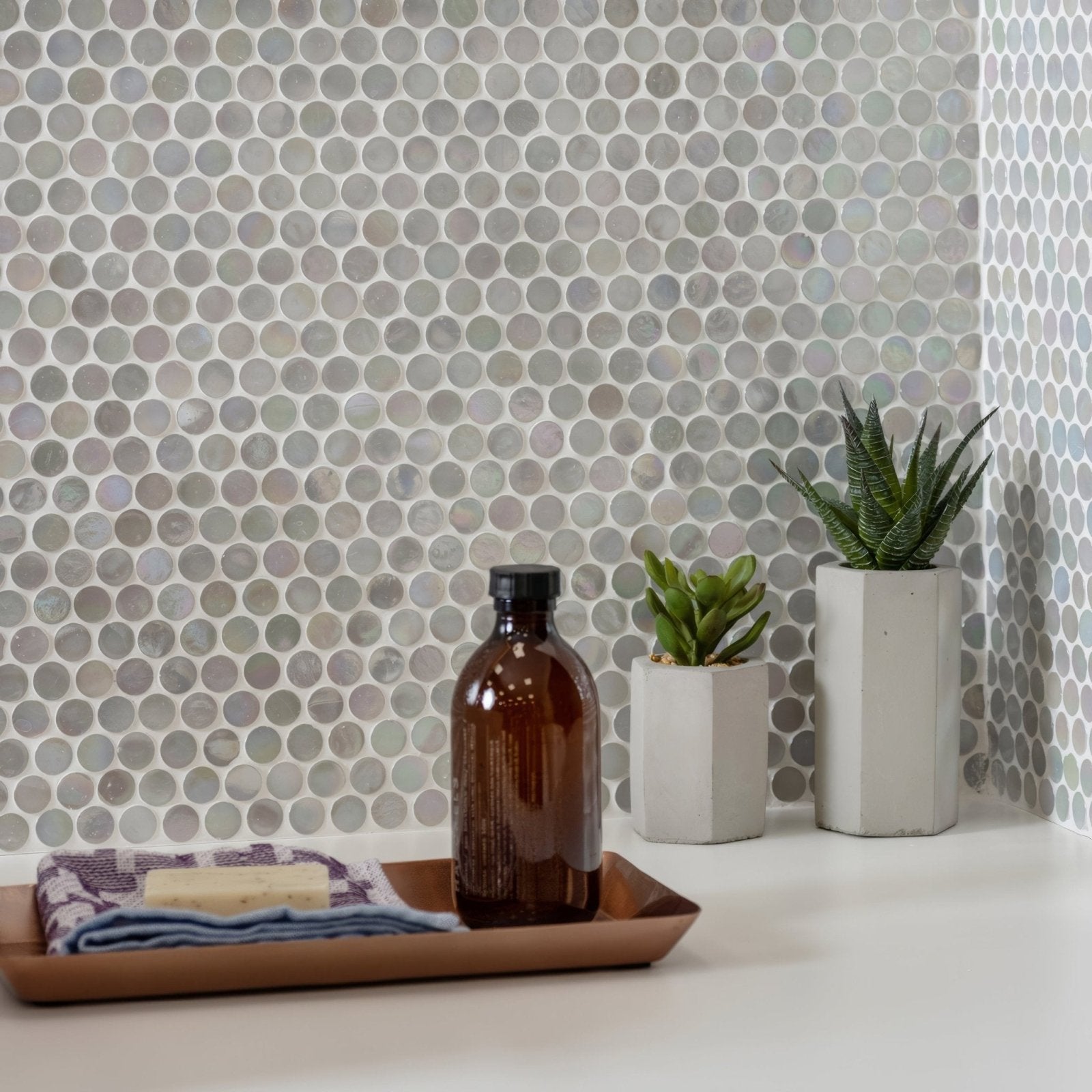 White Lady Iridescent Round Glass Mosaic iridescent round glass mosaic with a brown glass bottle on a wooden tray