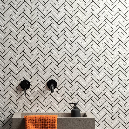 White Satin Chevron white satin chevron mosaic with a sink, black soap dispenser and orange towel