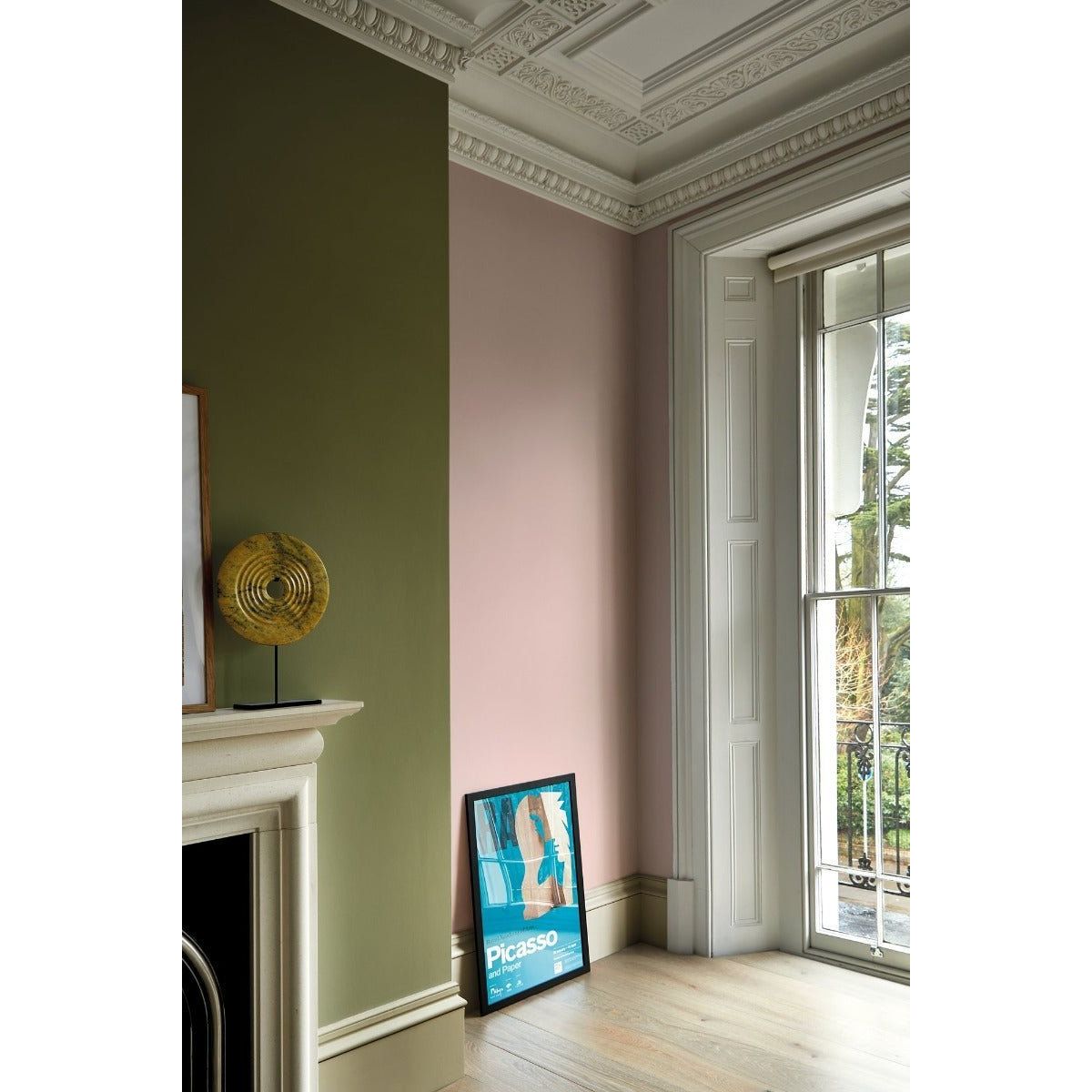 A framed picasso poster with bold blue and beige artwork leaning against a pink wall in wild olive collection