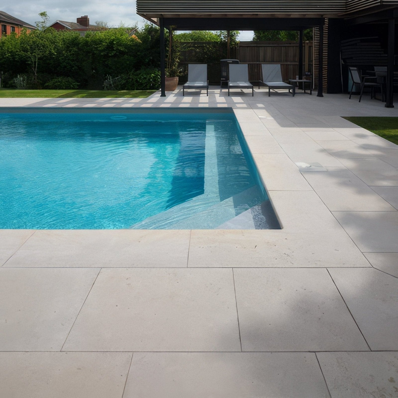 Rectangular wychwood limestone paving with etched finish featuring clear blue water and light beige stone border