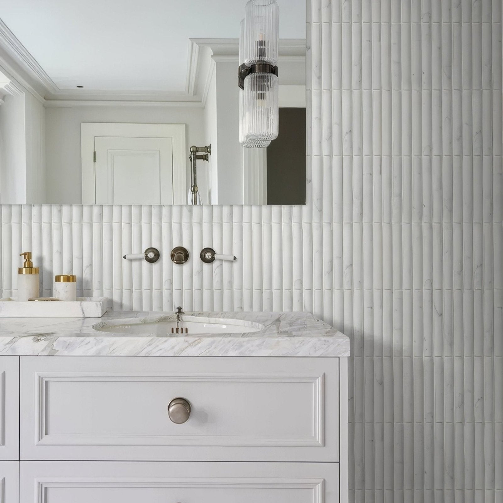 White marble bathroom vanity with silver round knob and elegant Zen marble reed mosaic vertical tile backsplash