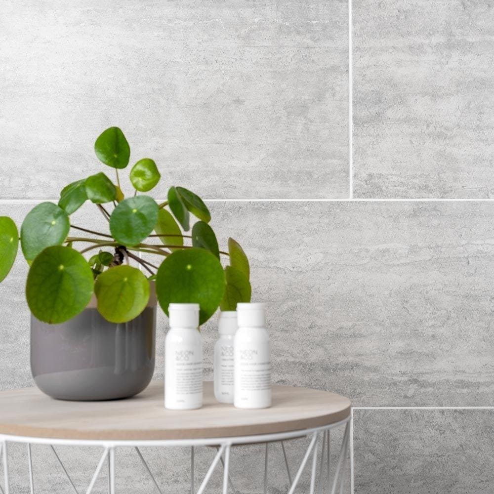 Atrium Marte Gris Tiles grey stone-effect tiles with a grey planter and pilea plant
