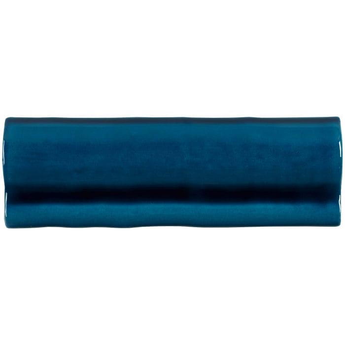 A glossy teal ceramic bastille torus moulding tile with a slightly irregular wavy edge for decorative use