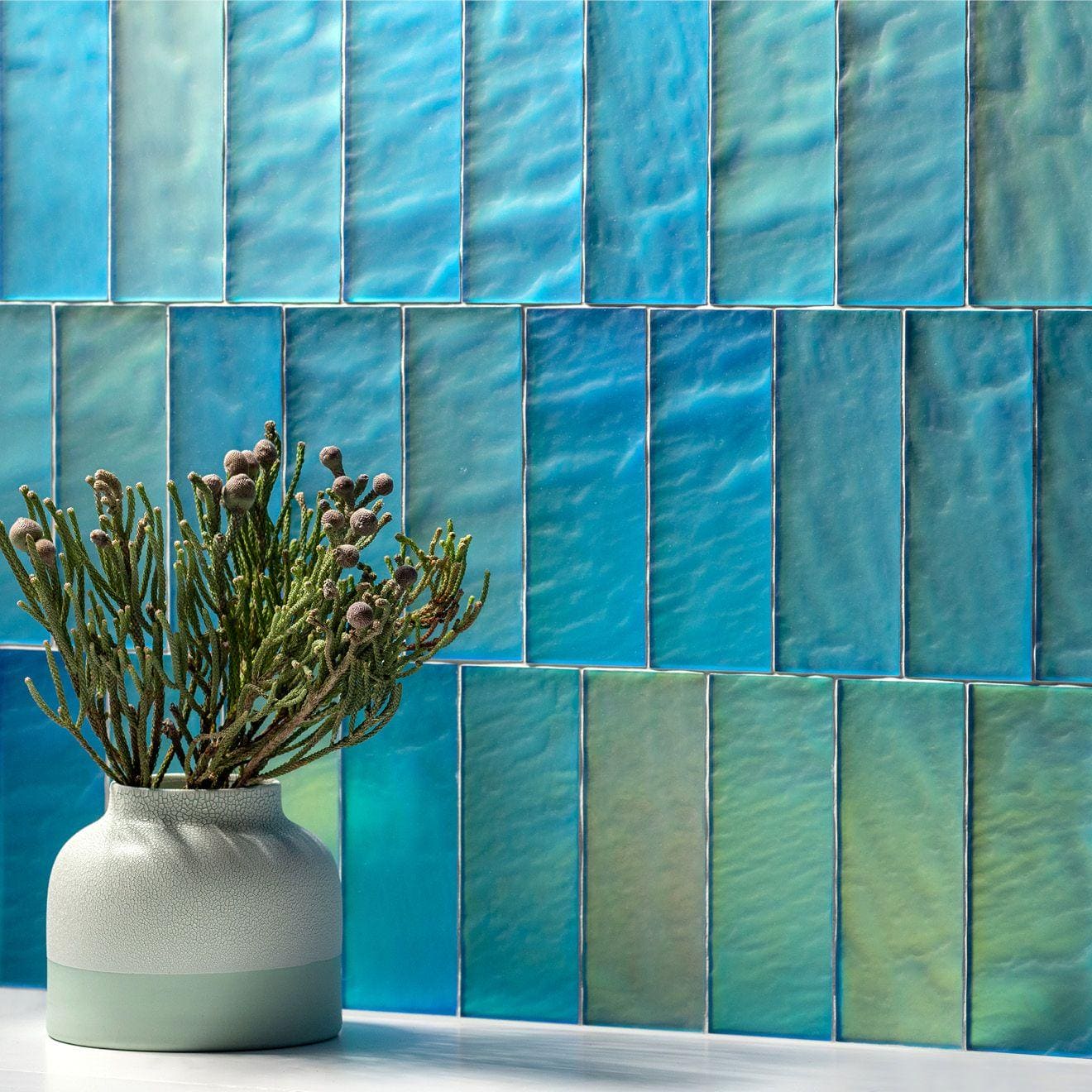 Blue Frost Brick Radiance iridescent teal and blue glass tiles styled with a two-toned ceramic vase