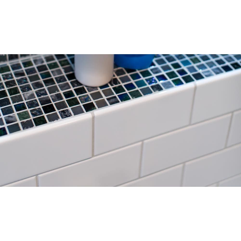 Brilliant white rounded long edge white subway tile backsplash with mosaic countertop of iridescent blue green glass tiles