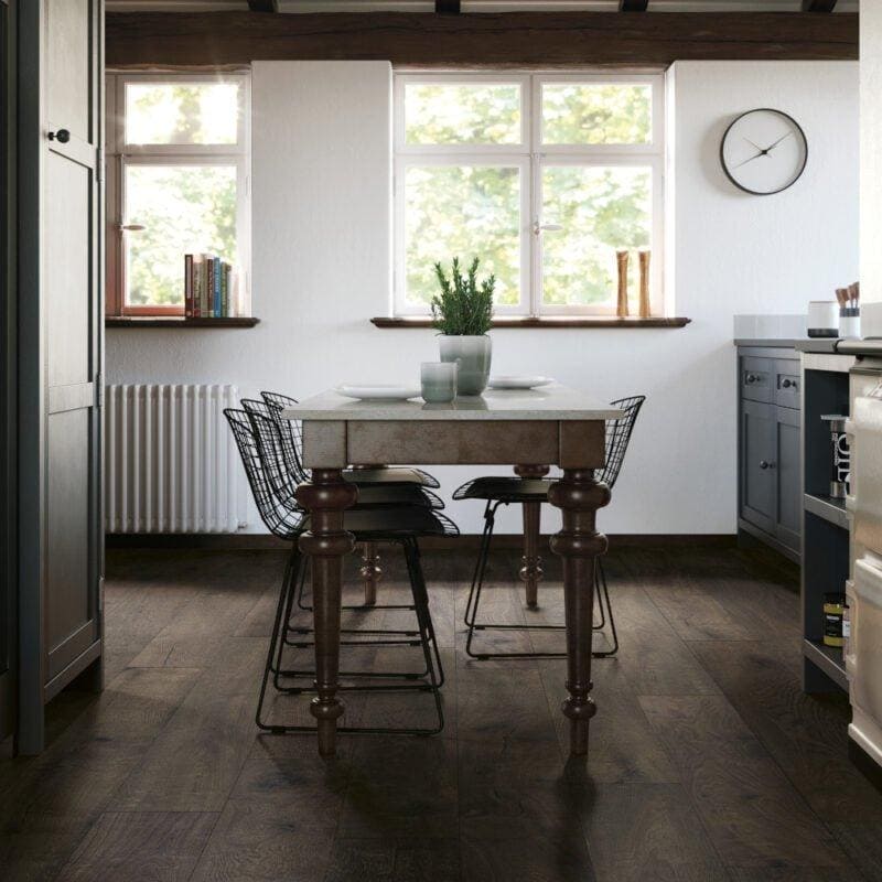 A canaiolo quercia rustic wooden dining table with dark brown ornate legs and a light gray stone top