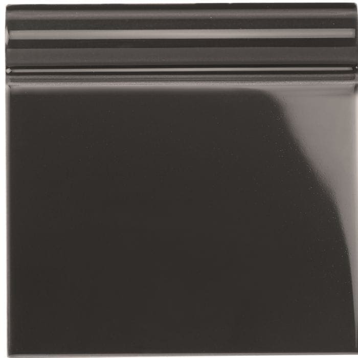 A glossy black ceramic charcoal grey skirting tile with a smooth reflective surface and subtle horizontal ridges