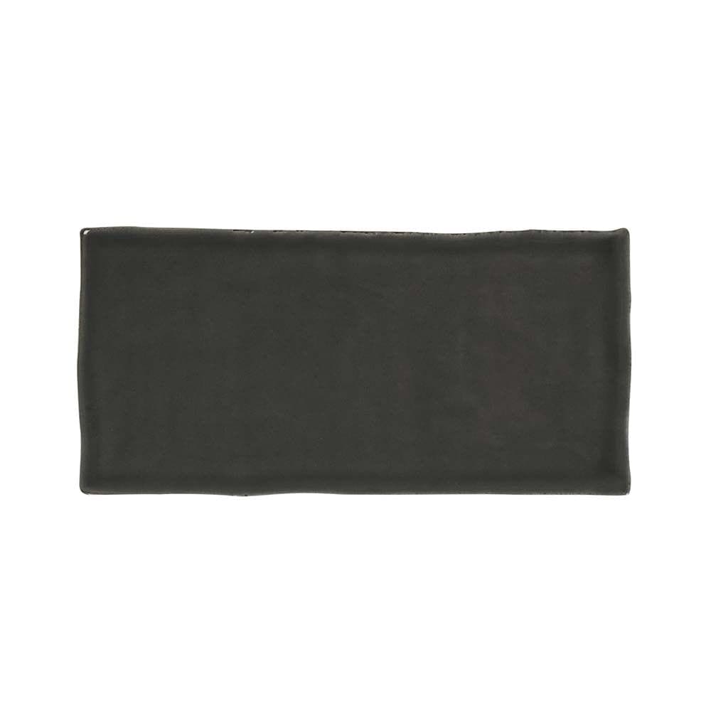 A sleek matte black rectangular ceramic clay smoke glazed wall tile 65x130mm with textured uneven edges