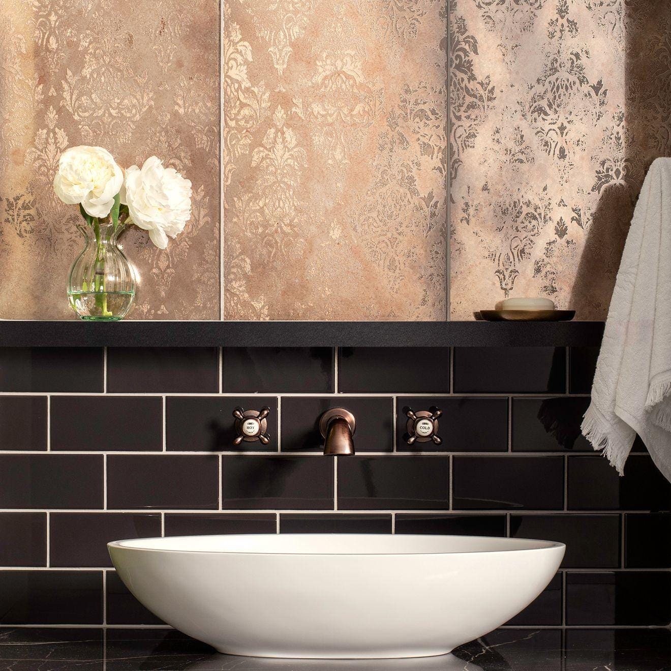 White ceramic vessel sink with a smooth rounded bowl shape in damask distressed rose gold finish