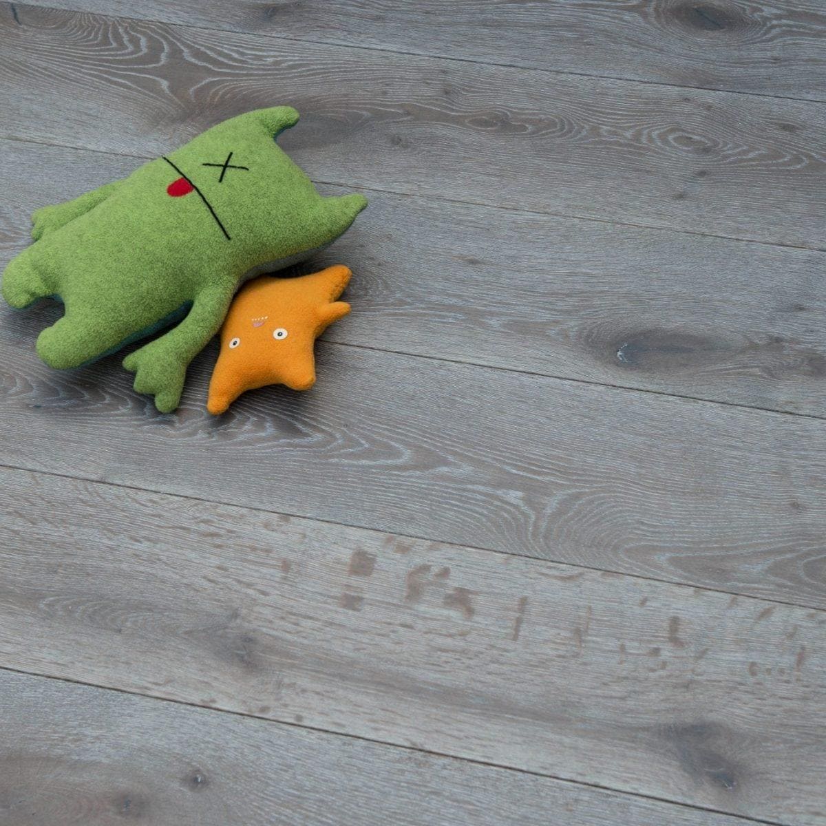 DC105 Deco Silver Haze grey oak engineered wood flooring with a green plush toy
