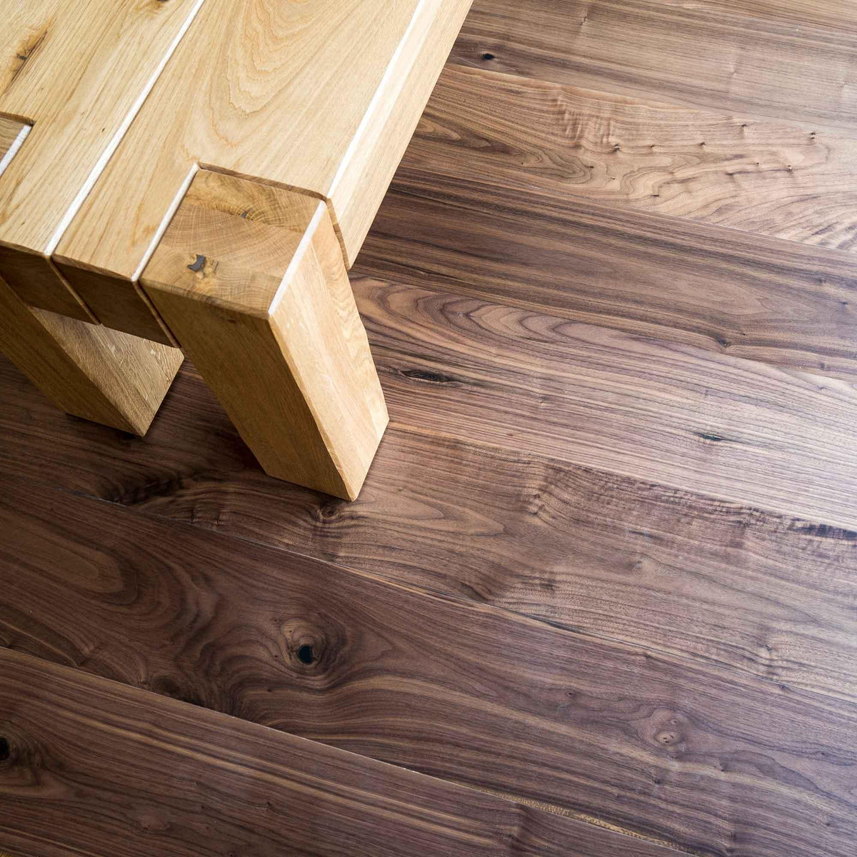 DC205 American Black Walnut dark walnut engineered wood flooring with an oak table leg