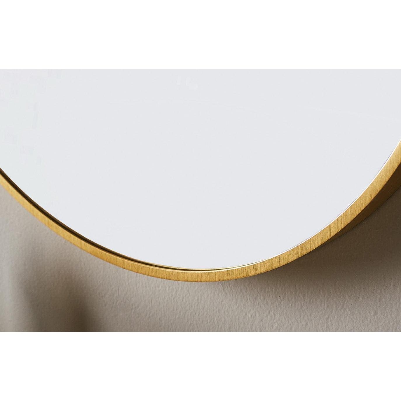 A sleek docklands round mirror 60cm with a brushed brass metal frame and circular design