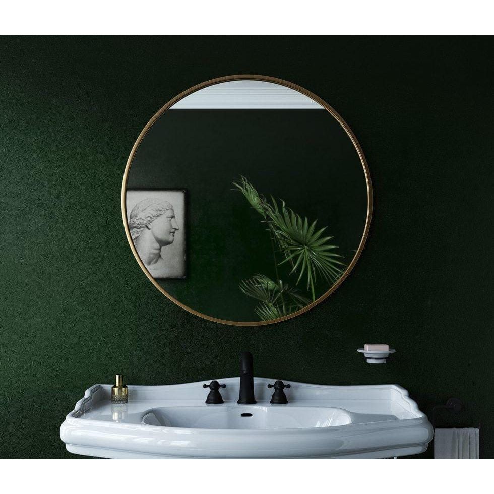 Docklands round mirror 60cm with a thin brushed brass frame reflecting a minimalist interior wall