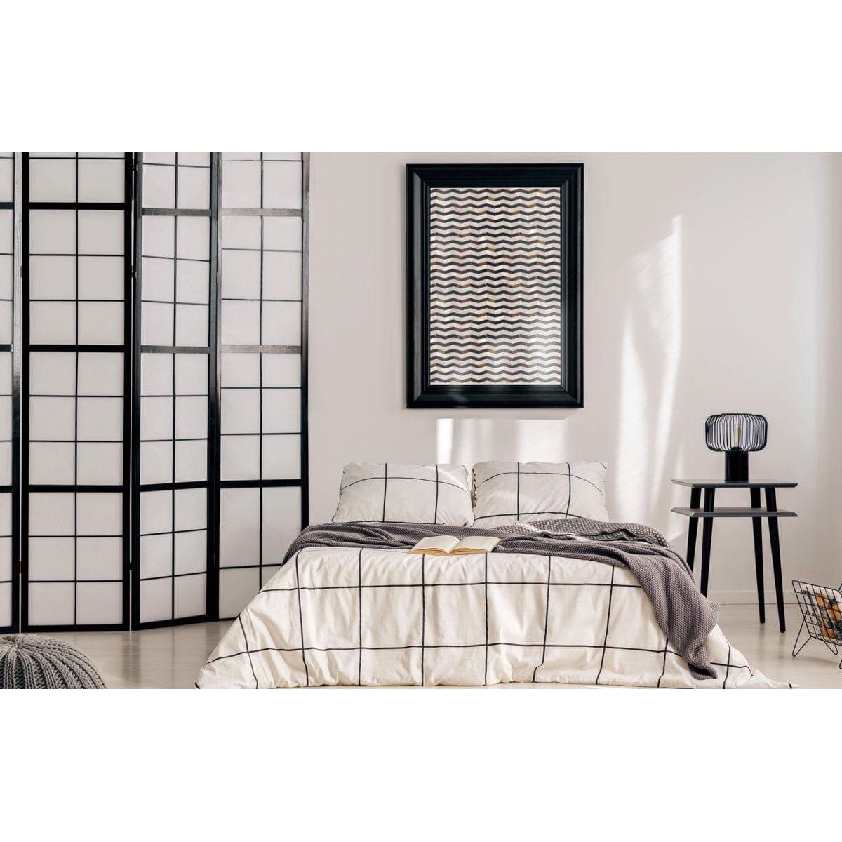 Black-framed feature panel wave abstract artwork with wavy gray and white pattern hanging above the bed