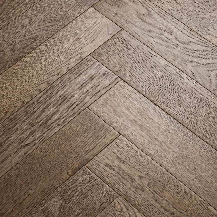 Gray oak hardwood flooring in a herringbone pattern from goodrich biscotti oak collection