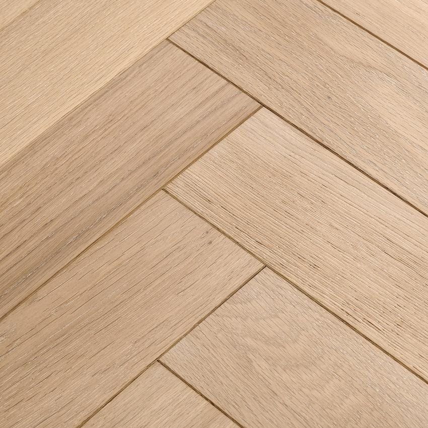 Light-colored hardwood flooring in a herringbone pattern made of ecru oak from goodrich