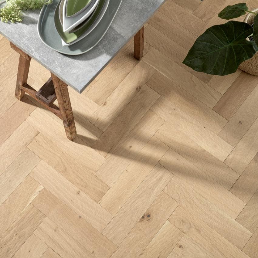 Light-colored goodrich raw oak hardwood floor with a herringbone pattern made from natural oak wood