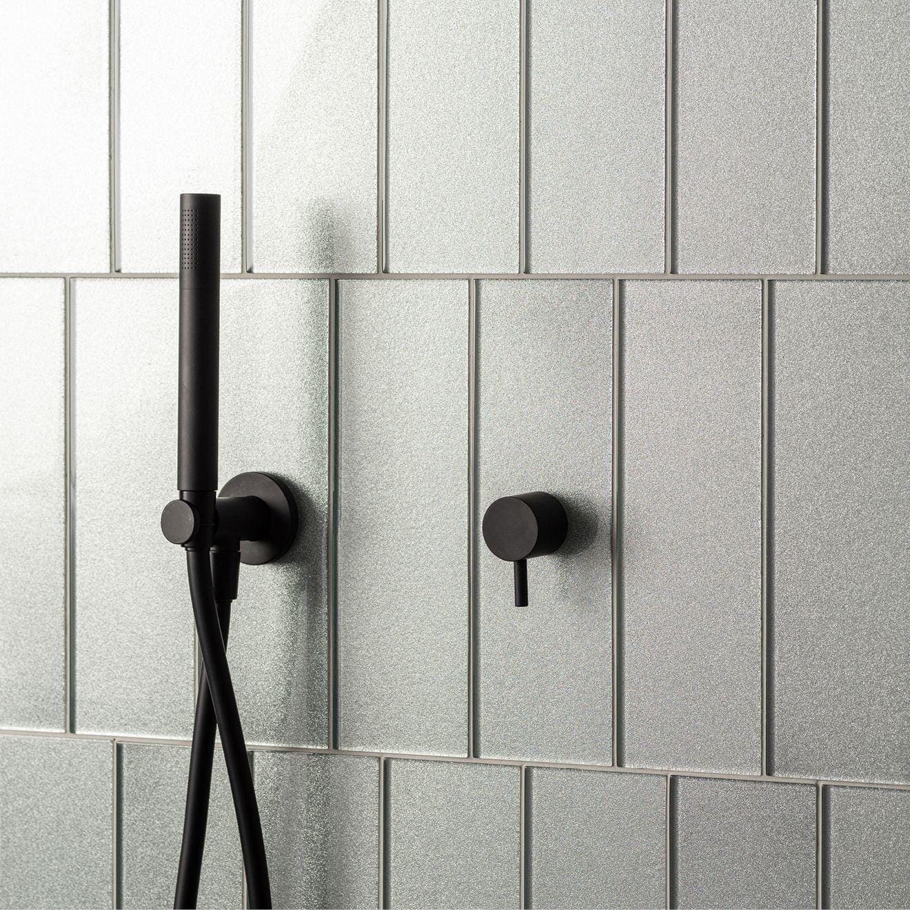 Hydrus Constellation Glass 300 x 100mm silver glass tiles with a black shower fixture