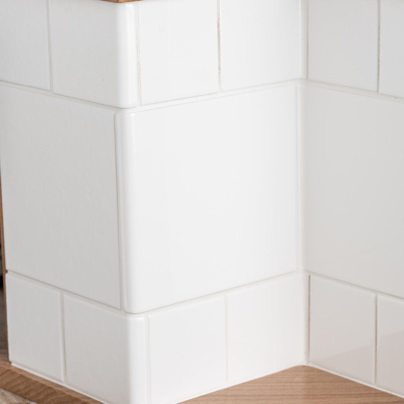 Internal half tile wrapping piece in brilliant white with rounded edges in a clean corner layout
