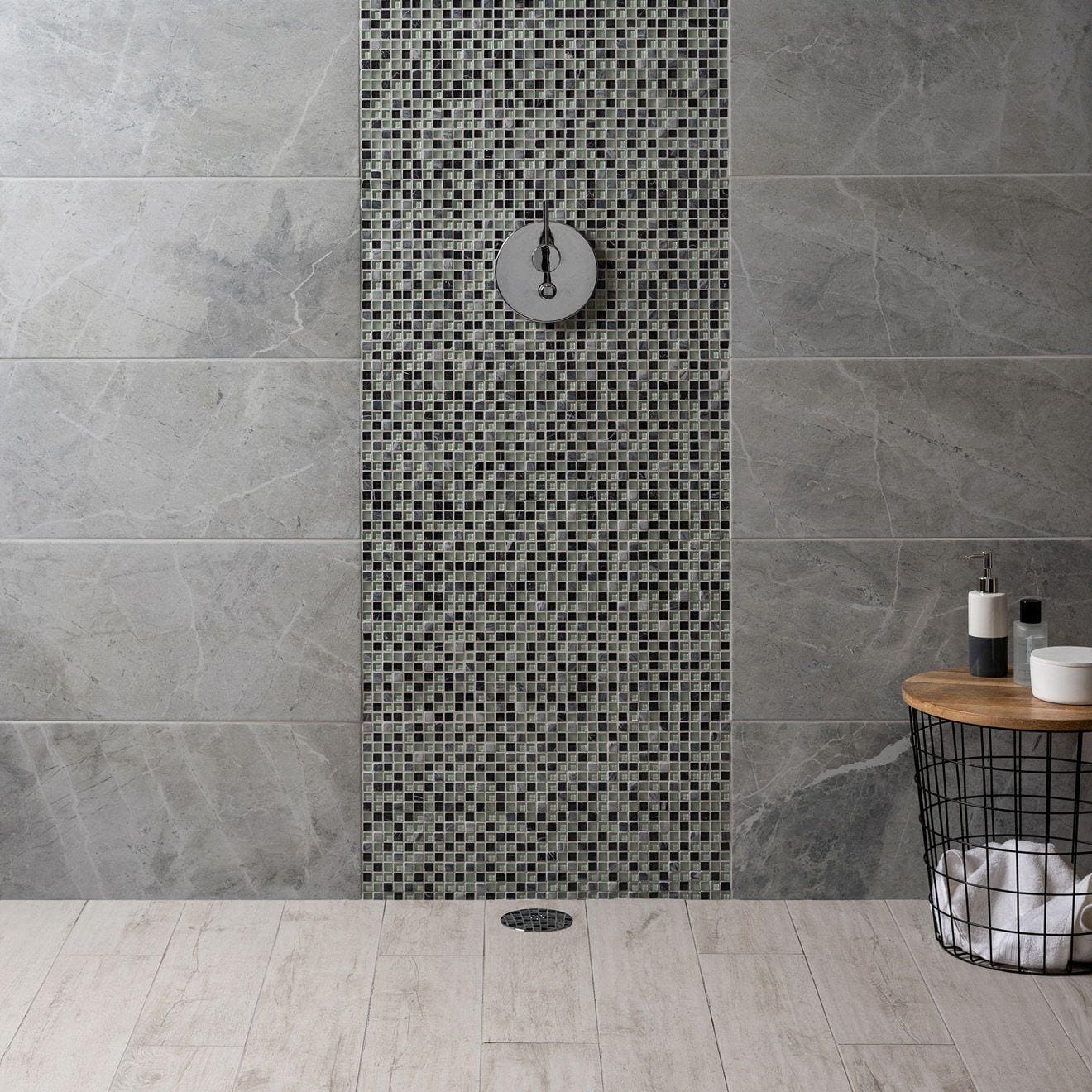 Circular chrome showerhead mounted on wall with black and gray lial earth and fire mixed mosaics tile accent