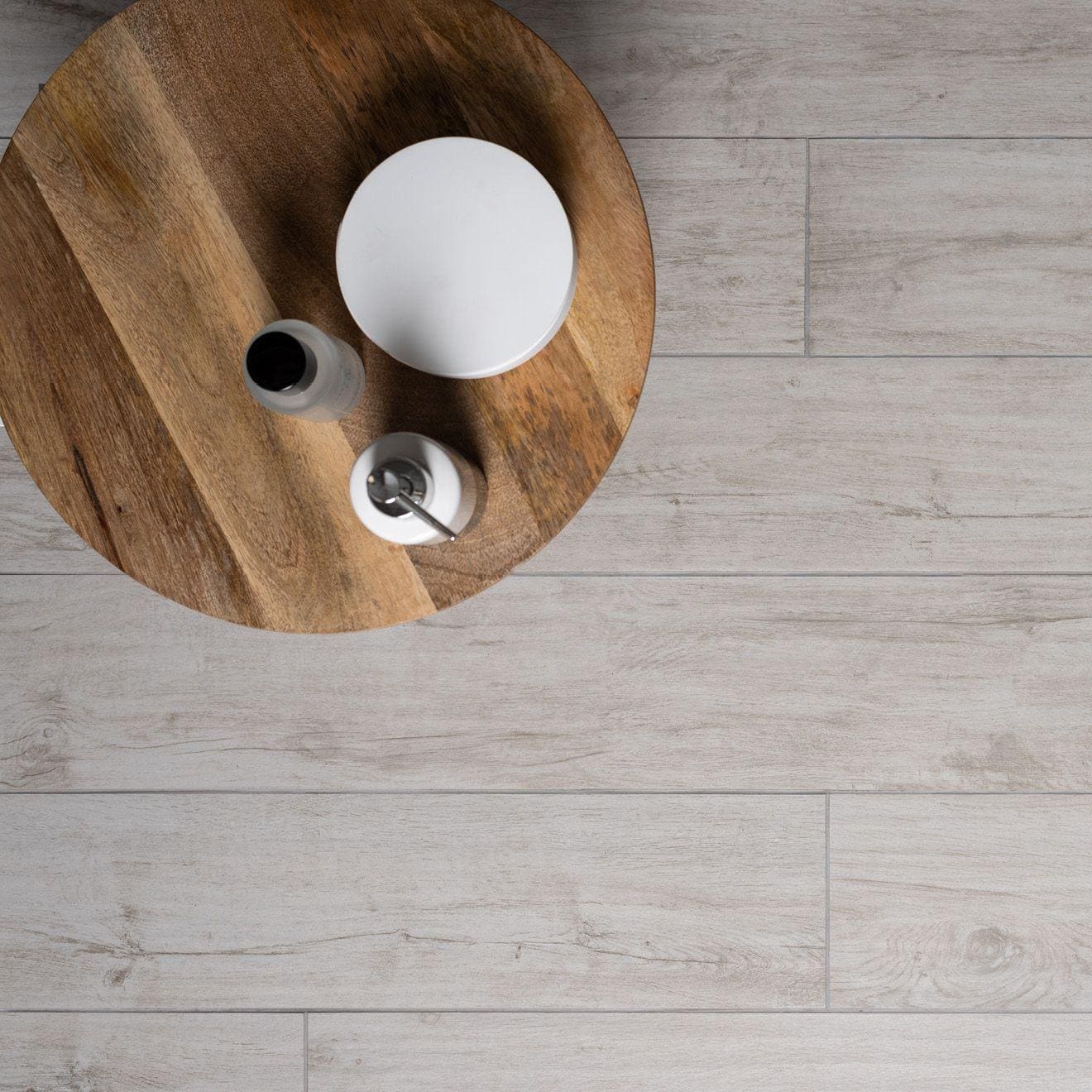 Lignum White Natural Rectified Glazed Porcelain white wood-effect porcelain tiles with a round wooden table