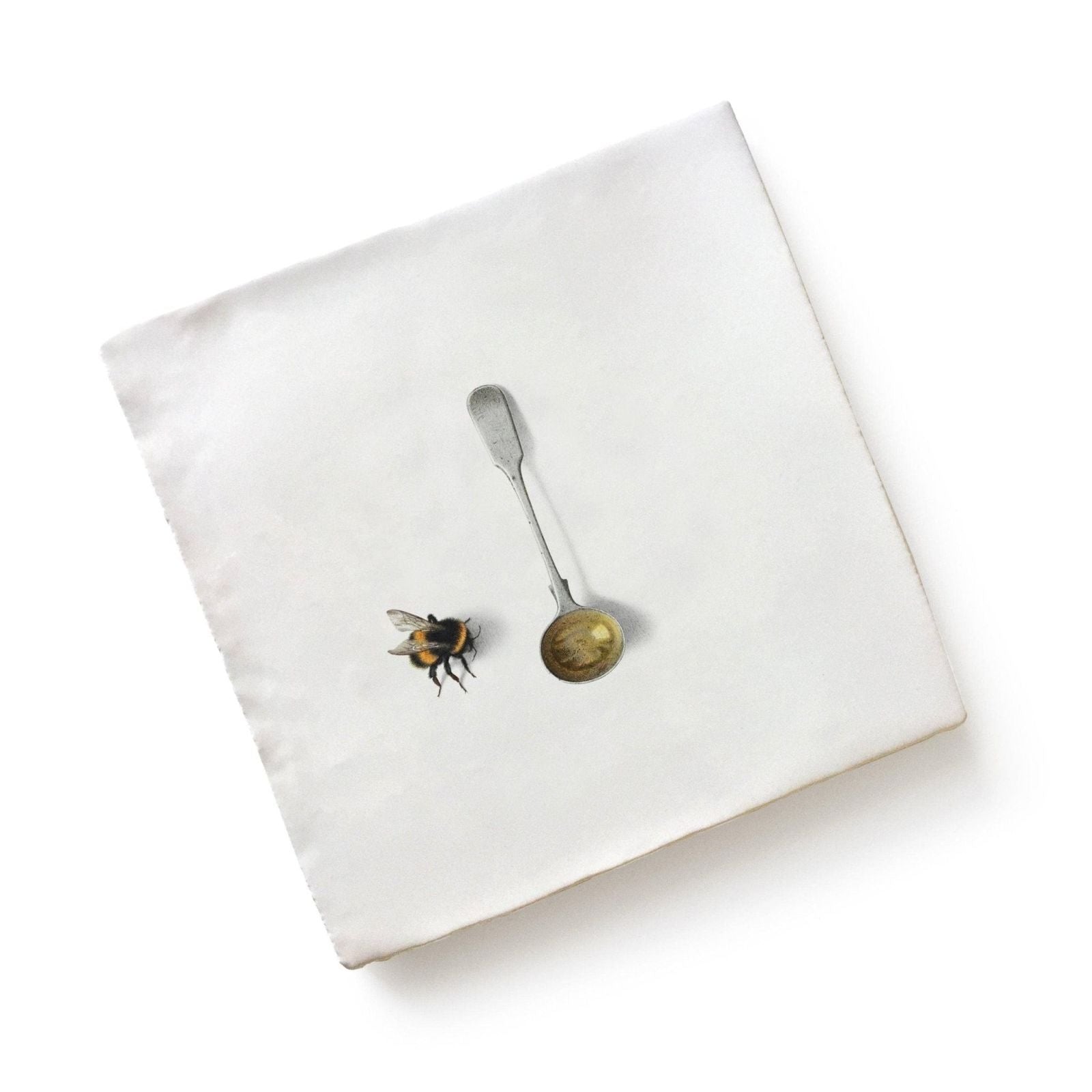 White linen napkin with printed bumblebee and silver spoon design from menagerie ceramic by michael angove