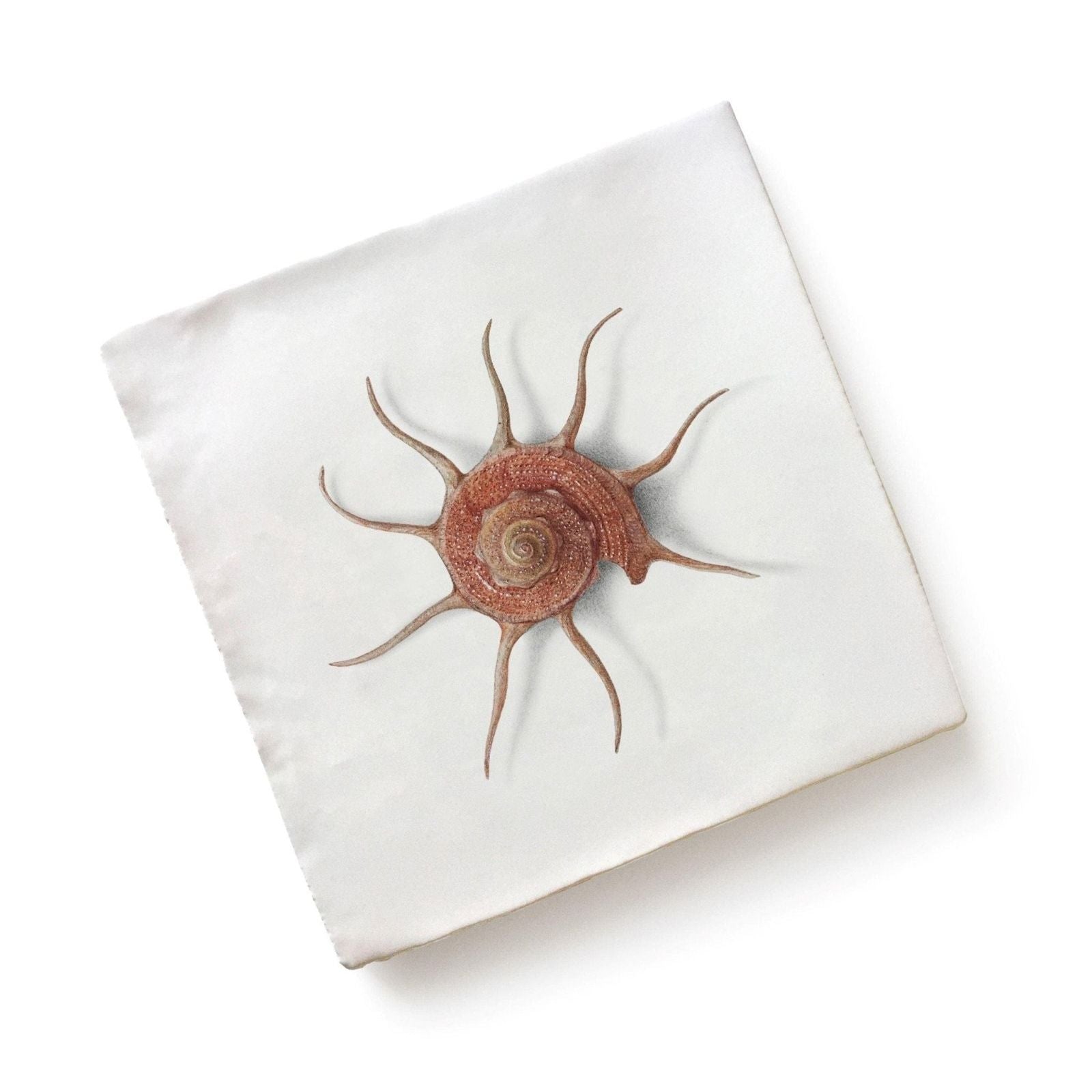 White square pillow with an embroidered reddish-brown seashell by Menagerie Ceramic by Michael Angove