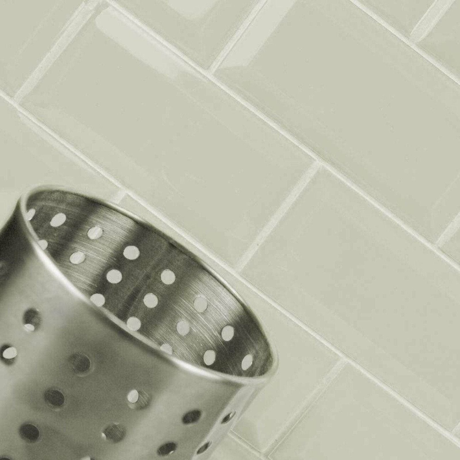 A metallic metro light grey gloss strainer with a brushed finish and evenly spaced circular perforated holes