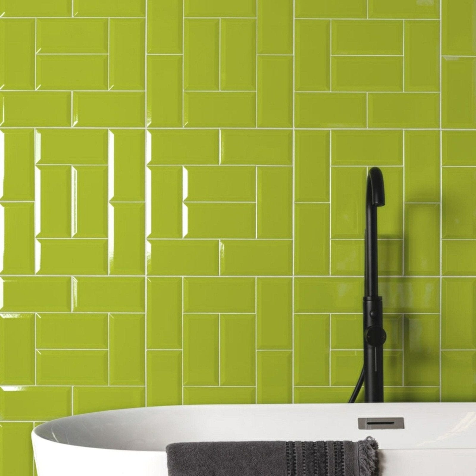 Vibrant lime green glossy subway tiles arranged in a herringbone pattern from metro menta gloss collection