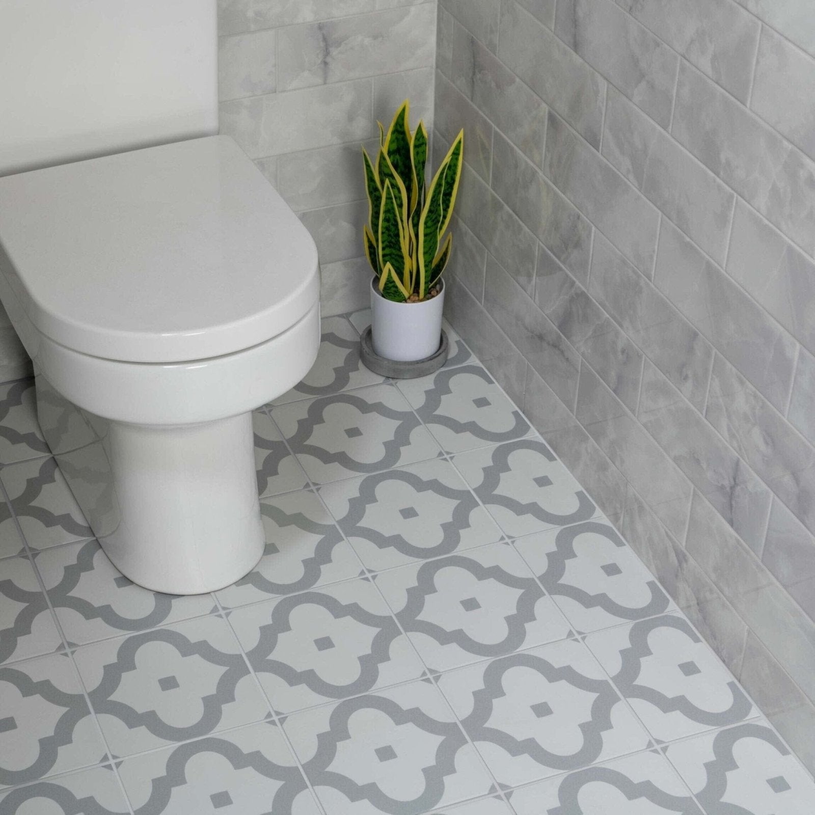 Gray and white patterned bathroom floor tiles with a quatrefoil design from onix smoke collection