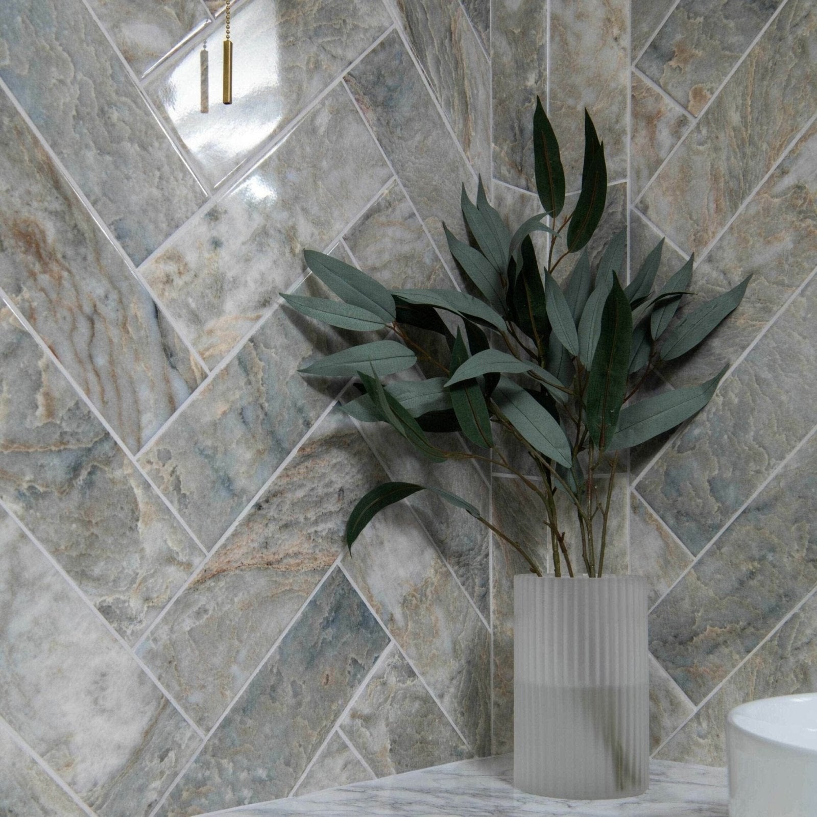 Onix Verde grey and beige marble-effect tiles with a ribbed vase and plant