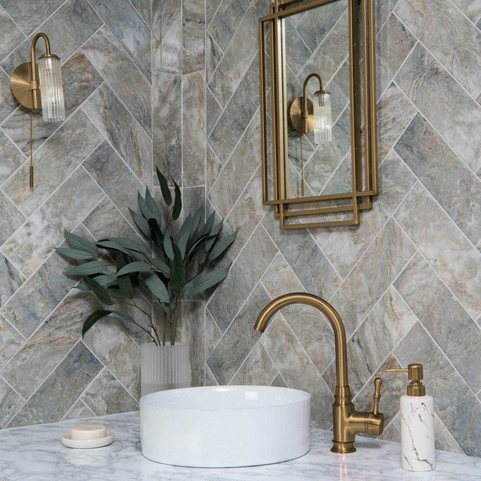 Onix Verde grey and beige marble-effect tiles with a vessel sink and brass tap