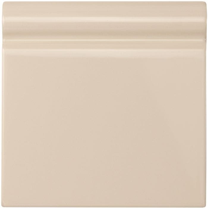 Ivory skirting tile made of cream-colored ceramic with a smooth glossy finish and subtle horizontal ridges on top edge