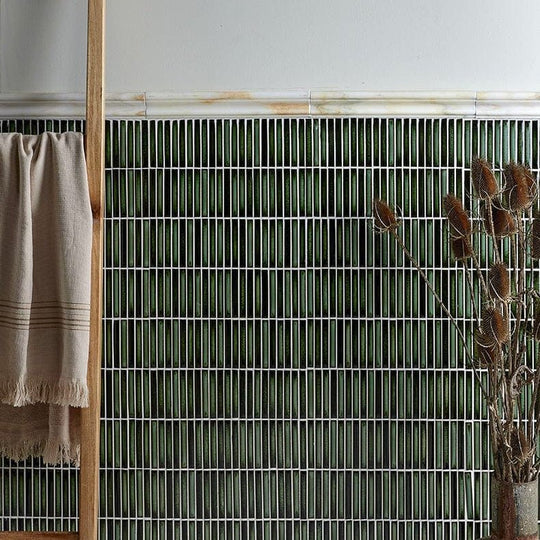 Palazzo Oro Marble Honed Moulding off-white marble moulding trim against dark green tiles