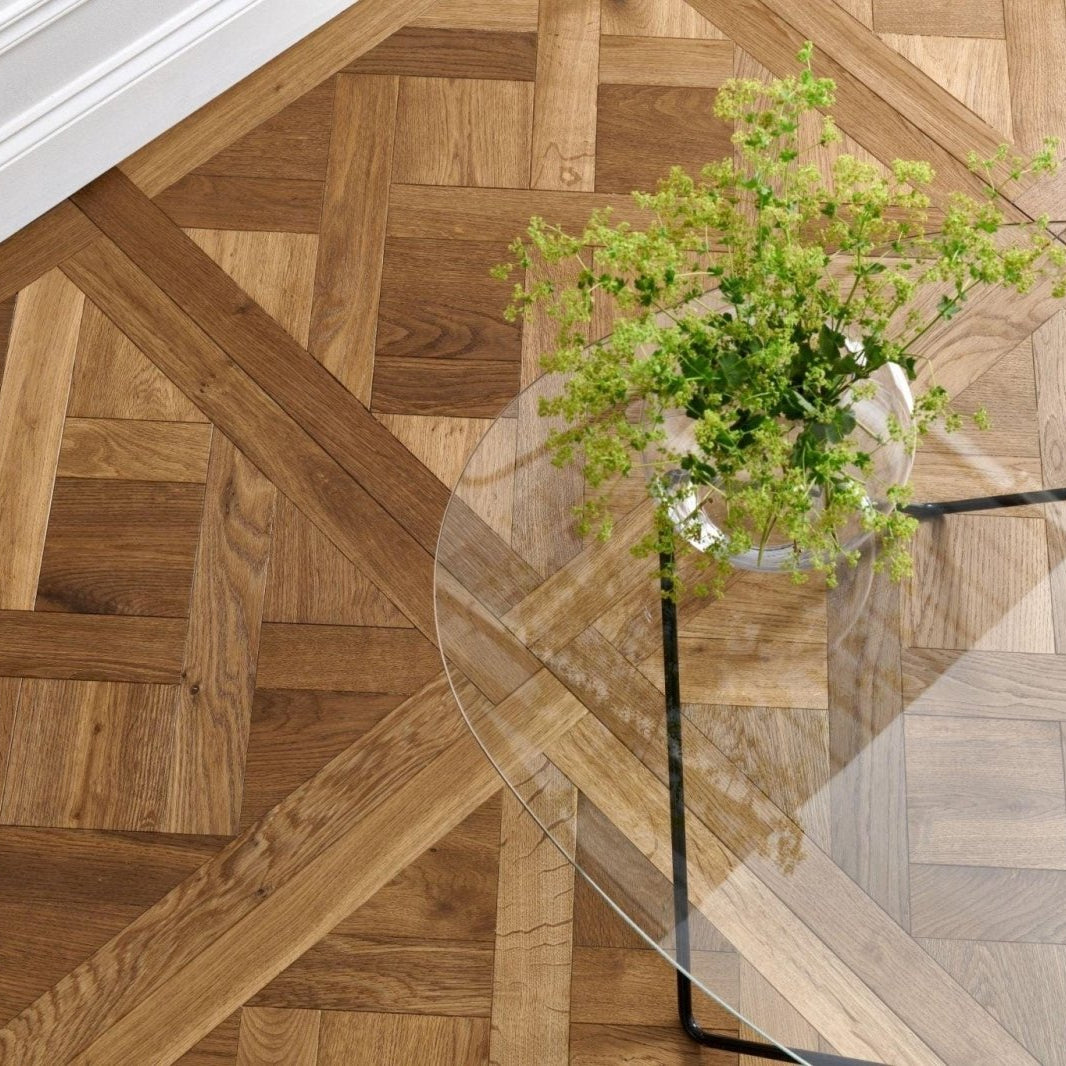 Wooden floor with geometric pattern in Woodpecker Sandringham Royal Oak Design Panels and a vase of flowers on a glass table.