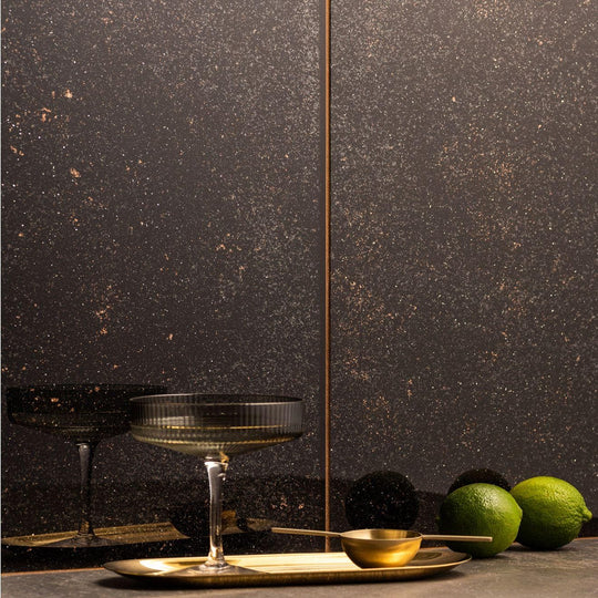 Solstice Decorative Glass black speckled glass tiles with a coupe glass on a brass tray