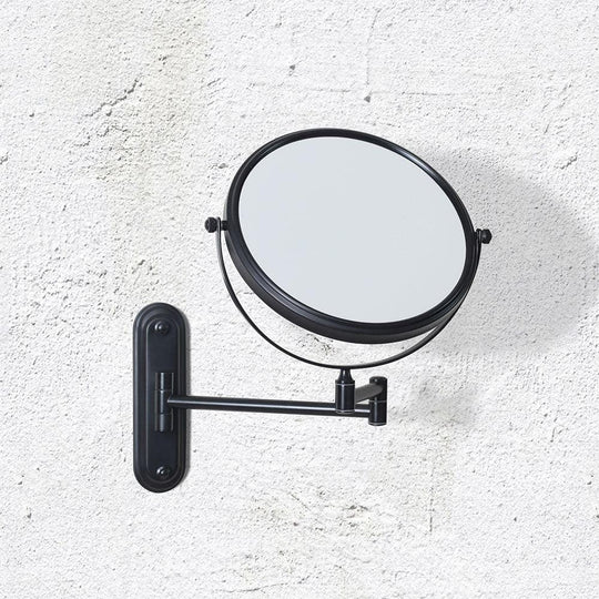 Black metal taylor reversible 5x magnifying wall mirror with circular frame and adjustable arm mounted on wall
