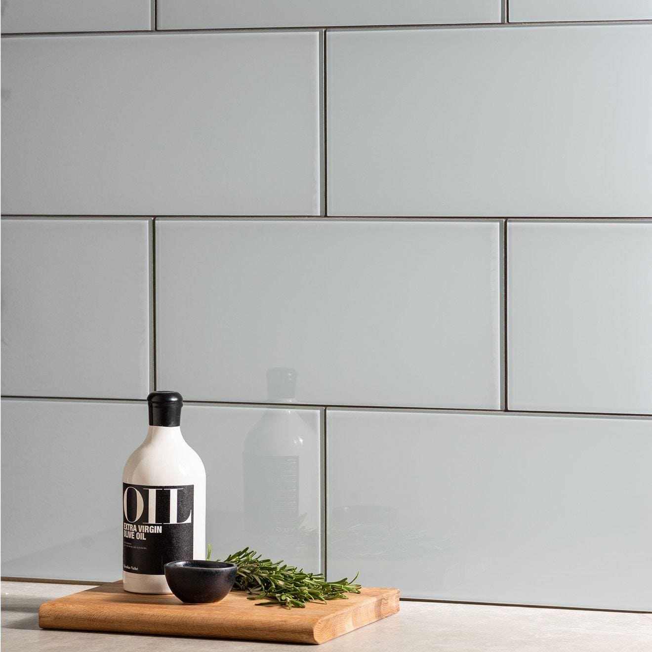 Thames Clear Glass 398 x 198mm grey glass tiles with a bottle of olive oil on a cutting board
