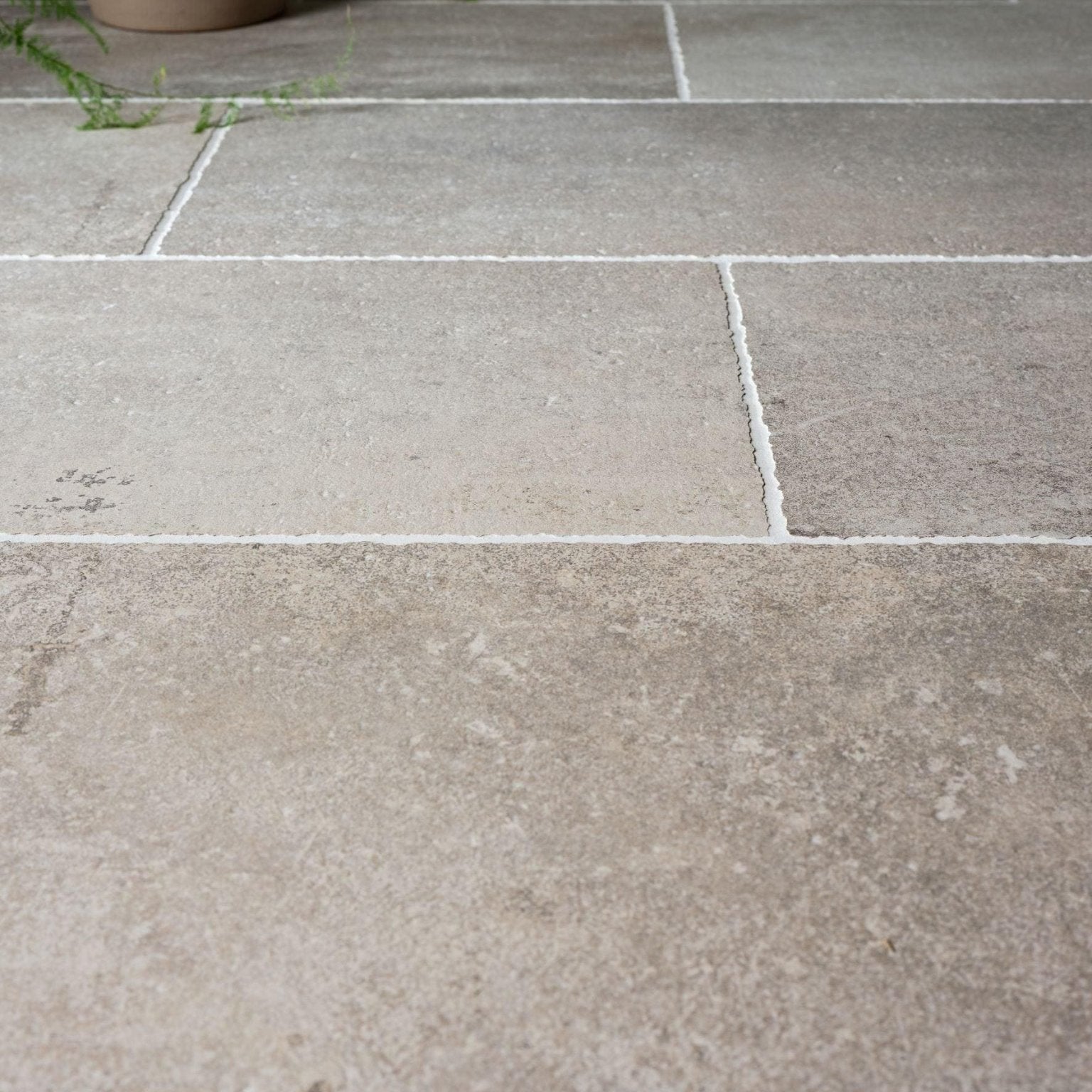 Wetherby porcelain gray stone tiles with subtle natural veining and white grout lines for flooring and walls