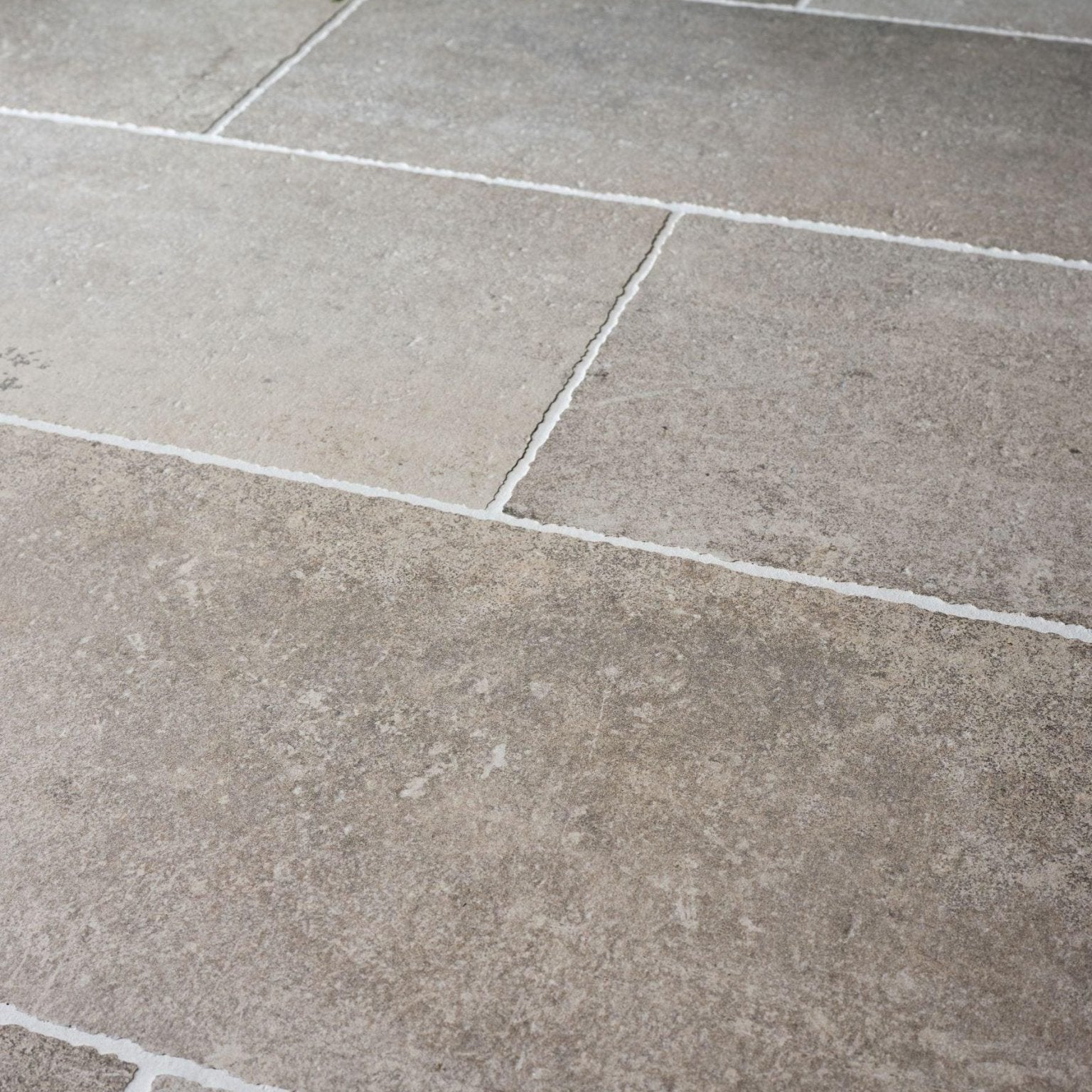 Wetherby porcelain gray stone tiles with textured natural finish and white grout lines for flooring