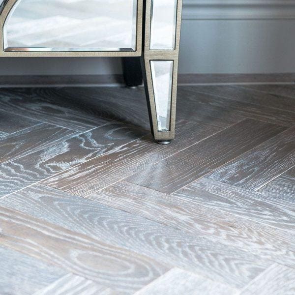 Gray herringbone-patterned hardwood floor with subtle wood grain finish in zb103 silver haze color and style