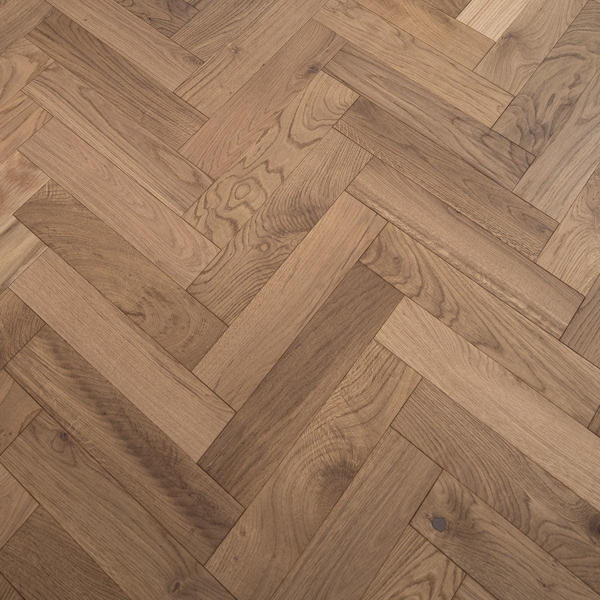 Warm-toned white smoked oak hardwood floor planks arranged in a classic herringbone pattern for elegant interiors