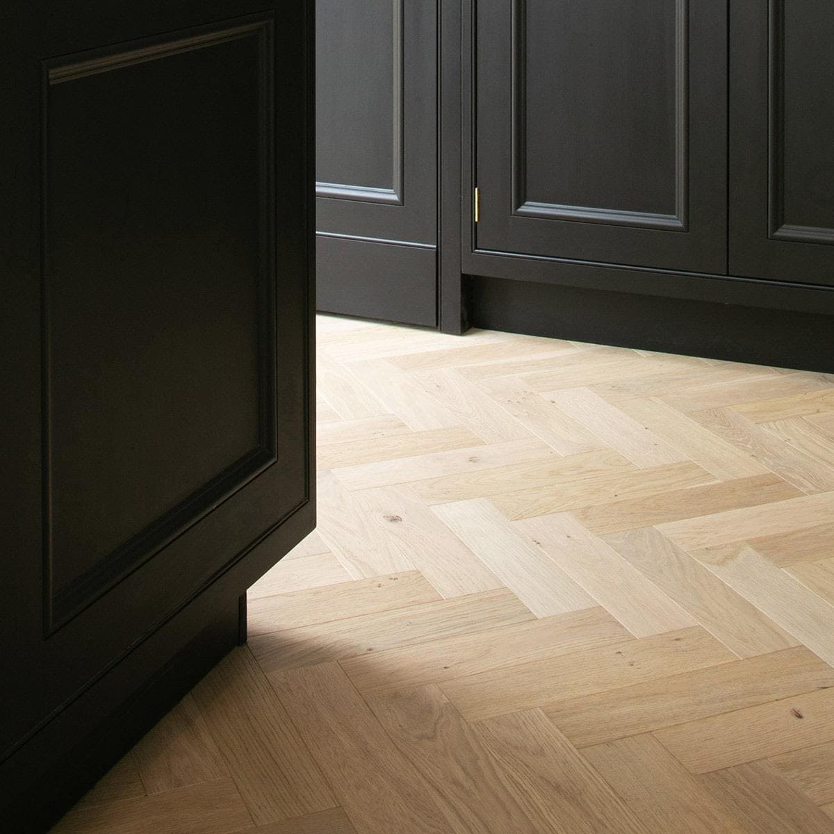 Light-colored shore drift oak wood planks arranged in a herringbone pattern for flooring design