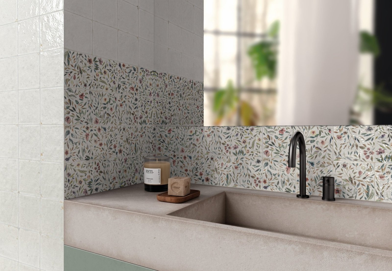 Modern bathroom sink with matte concrete finish and black fixtures against botanical tiled wall in muted greens and browns
