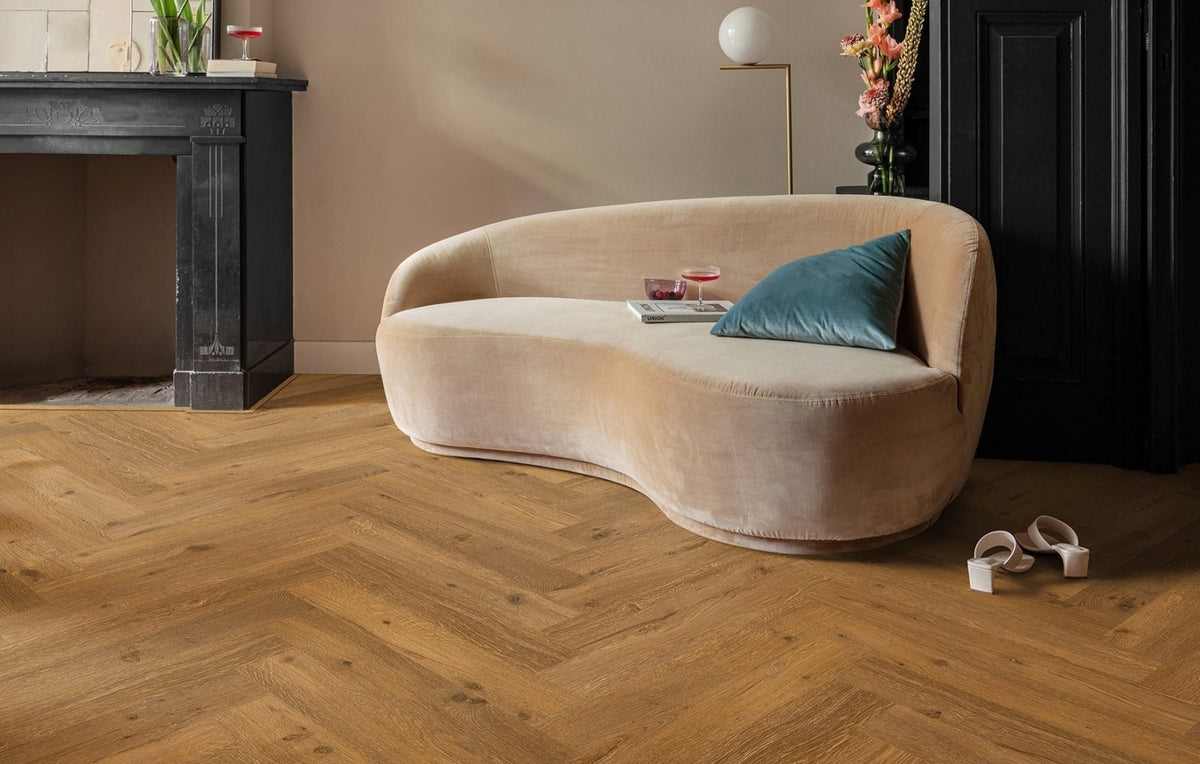 Beige velvet curved sofa with teal cushion highlighting luxury vinyl flooring benefits in living room setting